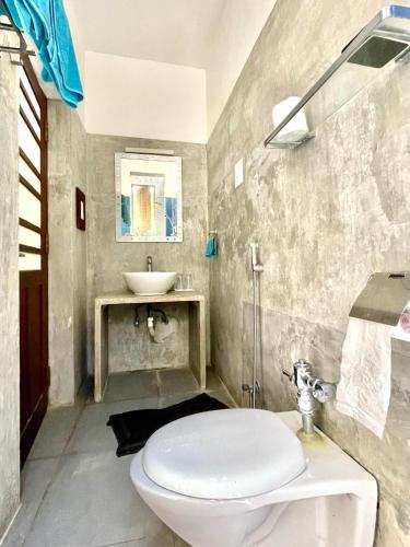 a bathroom with a toilet and a sink at Isana Beach House in Tangalle