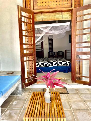 a plant in a vase sitting on a wooden bench at Isana Beach House in Tangalle
