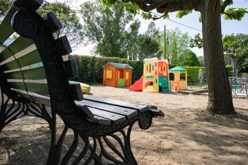 a park bench sitting in front of a playground at Le Clos des Bruyères in Vallon-Pont-dʼArc