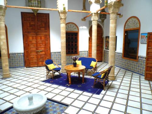 a room with chairs and a table in a building at Riad Marco Andaluz in Sale