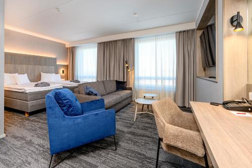 タルトゥにあるDorpat Hotelのベッドとソファのあるホテルの部屋
