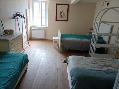 a bedroom with two bunk beds and a ladder at Le Moulin Neuf in Beaupréau