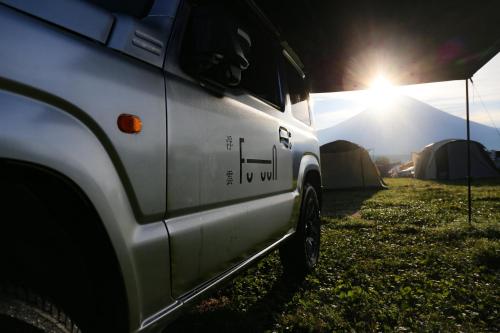 a white truck parked in a field with tents at FUUUN S Camping Car in Fujinomiya