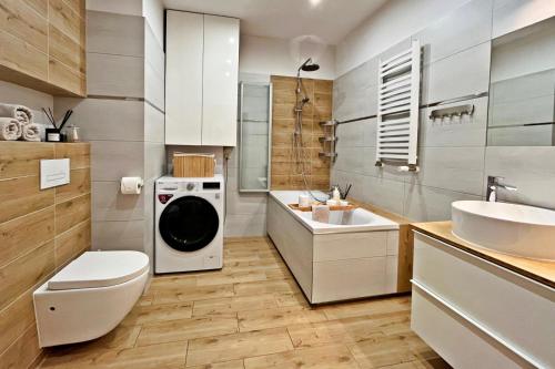 La salle de bains est pourvue d'un lave-linge et d'un lavabo. dans l'établissement HARMONY Apartment - Zator Energylandia, à Zator