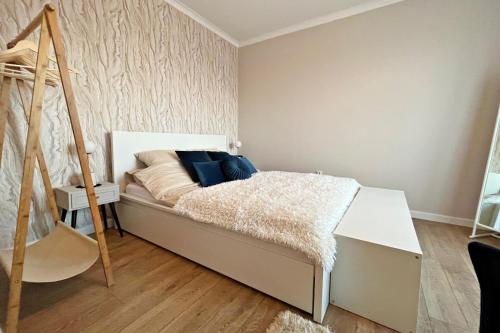 a small bedroom with a bed with blue pillows at HARMONY Apartment - Zator Energylandia in Zator