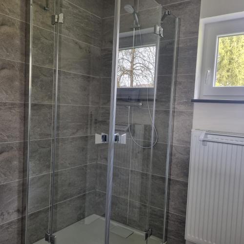 a shower with a glass door in a bathroom at Ferienwohnung-Naurath in Naurath