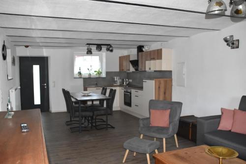a living room and kitchen with a table and chairs at Ferienwohnung-Naurath in Naurath