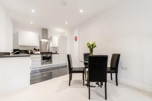 a kitchen and dining room with a table and chairs at Roomspace Serviced Apartments - Nouvelle House in Sutton