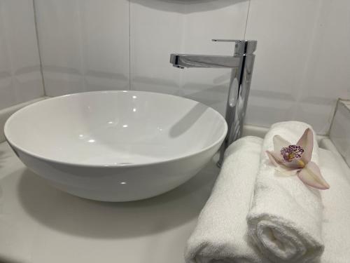 lavabo blanco y toallas en la encimera del baño en Hotel Pegasus Crown en Shillong