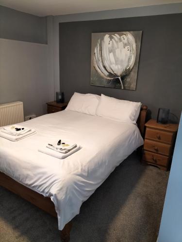 a bedroom with a large white bed with two trays on it at The Castle Inn in Ebbw Vale