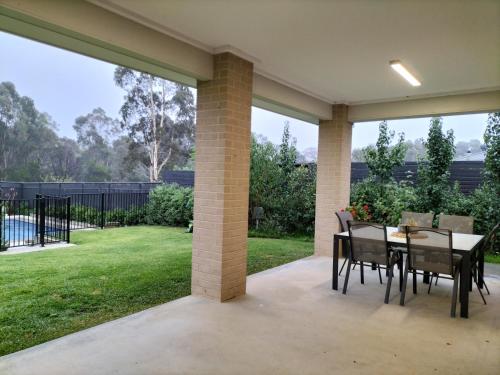a patio with a table and chairs and a yard at Harvey's Haven in Castlemaine