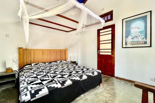 a bedroom with a black and white bed in a room at Isana Beach House in Tangalle