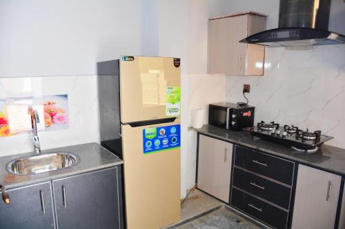 a small kitchen with a sink and a refrigerator at Khyber Guest House Swat in Saidu