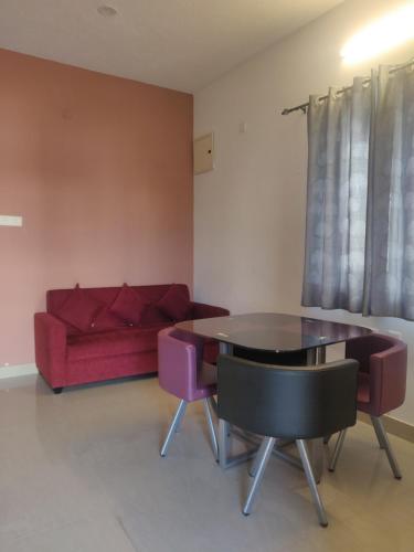 sala de estar con mesa y sofá rojo en Eco Village - No Alcohol Zone, en Yelagiri