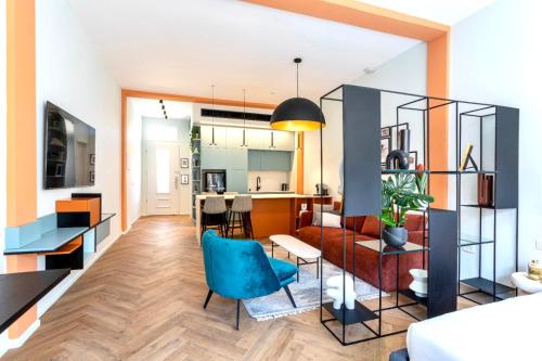 een woonkamer en een keuken met een bank en stoelen bij De Pejoto in Tel Aviv