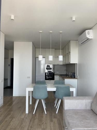 a kitchen and living room with a table and chairs at VIP Apartmens Avalon in Lviv
