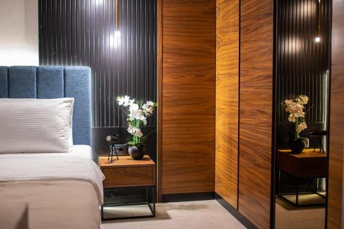 a bedroom with a bed and wooden walls at Enyana Luxury Suites in Kotor