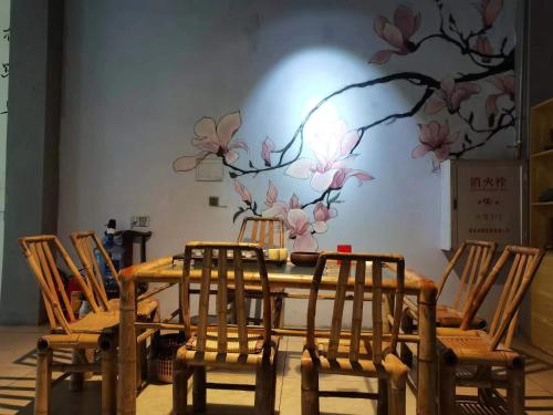 永定的住宿－Tulou Panda Homestay，墙上挂着带花壁画的桌椅