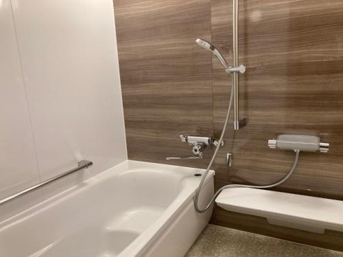 a bath tub in a bathroom with a shower at Hotel Park in Gifu