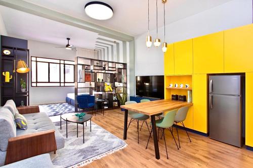 a living room with a table and yellow walls at De Pejoto in Tel Aviv