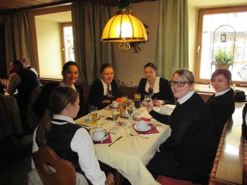 a group of people sitting around a table in a restaurant at Hotel Untermetzger in Zell am Ziller