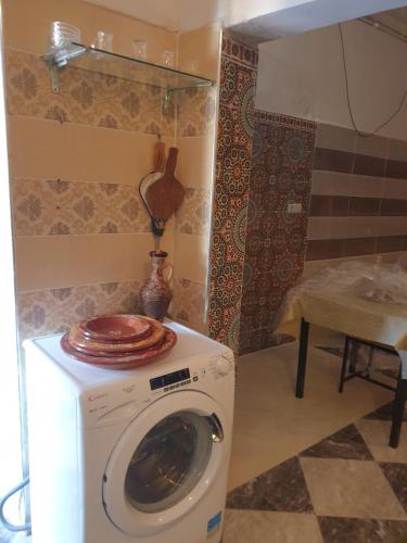 a washing machine with a plate on top of it at Maison de ville in Oulad Hamdane