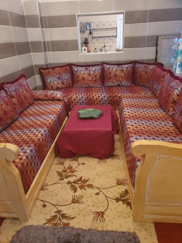 - un salon avec un canapé et une table dans l'établissement Maison de ville, à Oulad Hamdane