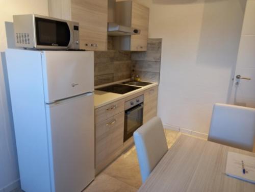 a kitchen with a white refrigerator and a table at Rocca Palazzaccio in Impruneta
