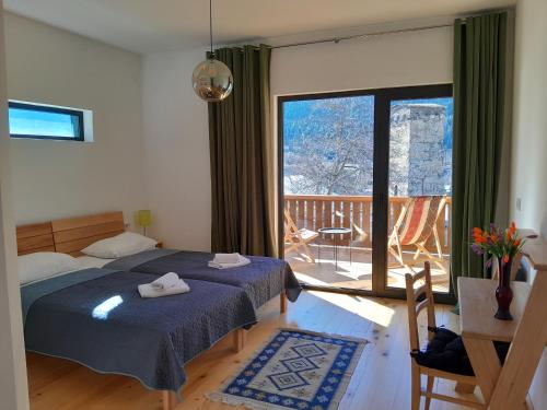a bedroom with a bed and a view of a balcony at Hotel Lamish in Mestia