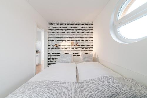 ein weißes Schlafzimmer mit einem Bett und einem Fenster in der Unterkunft Komfort-Hausboote am Naturhafen Krummin in Krummin
