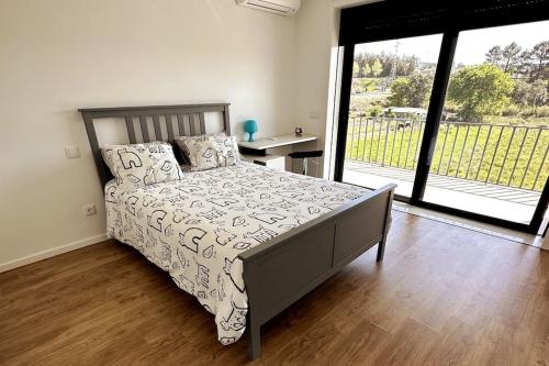 1 dormitorio con 1 cama y puerta a un balcón en Magnifique Villa avec piscine, 