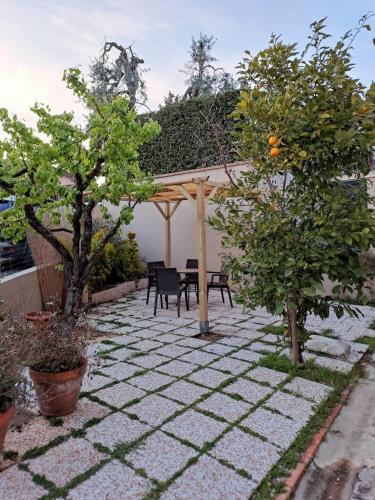 a patio with a table and chairs and trees at MADI' casa vacanze in Laiatico