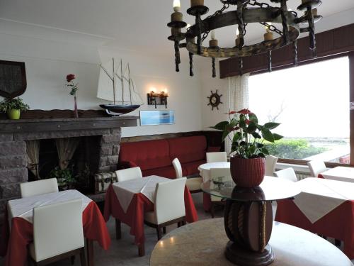 a restaurant with tables and chairs and a fireplace at Hotel Uhainak in Hendaye