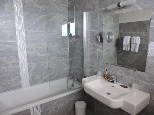 a bathroom with a sink and a shower and a tub at Hotel Uhainak in Hendaye