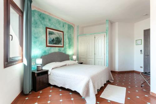 a bedroom with a bed and a blue wall at Hotel Stefania Boutique Hotel by the Beach in Olbia