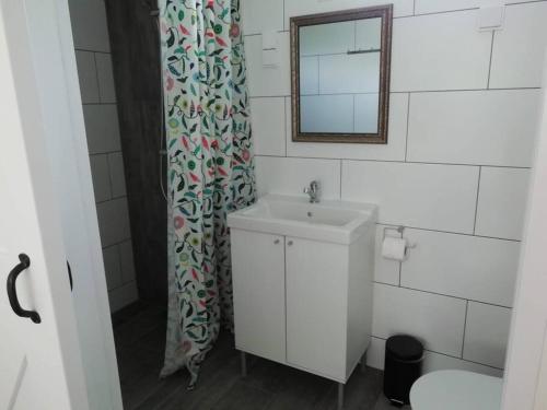 baño con lavabo y cortina de ducha en Strandhuisje DAAN dicht bij zee en strand, en Callantsoog