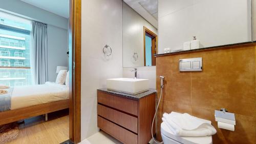 uma casa de banho com um lavatório e uma cama em Primestay - 2020 Marquis 1BR Al Barsha South em Dubai