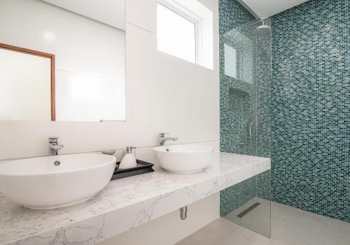 a white bathroom with a sink and a shower at Vimaan Vilai - Secluded Pool Villa in Nathon Bay