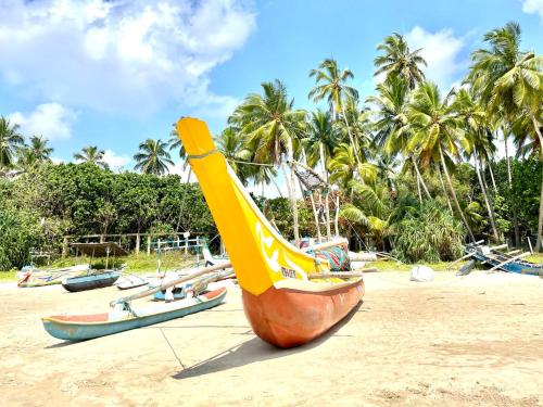 a large yellow boat sitting on a sandy beach at Isana Beach House in Tangalle