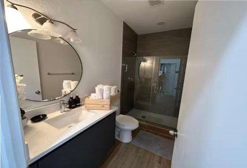 een badkamer met een wastafel, een toilet en een spiegel bij Enjoy our brand new home close to Hollywood in Hallandale Beach! in Hallandale Beach