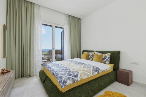Un dormitorio con una cama y una ventana grande. en Luštica Magnolia apartment, en Tivat