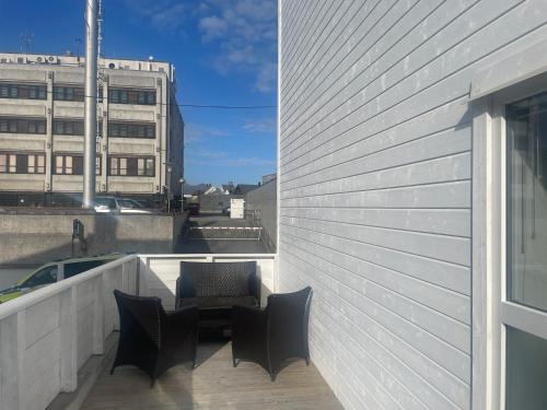a balcony with chairs and a table on a building at 3 rooms apartment in Center in Ålesund