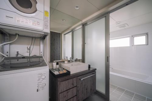 W łazience znajduje się umywalka i lustro. w obiekcie Villa Conte w mieście Miyako-jima