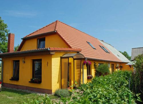 ThesenvitzにあるFerienwohnungen in Lipsitz auf Rueの赤屋根の小黄色い家