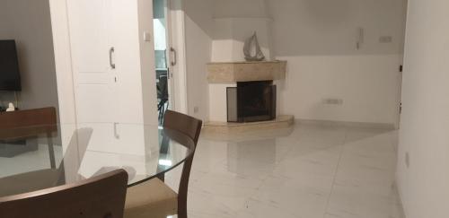 a dining room with a glass table and a fireplace at Zelea Deluxe Apartment (BREAKBOOKING CY) in Limassol