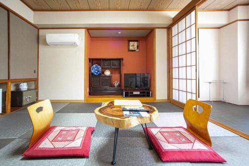 a living room with a table and two chairs at Yufuin Akarinoyado in Yufuin
