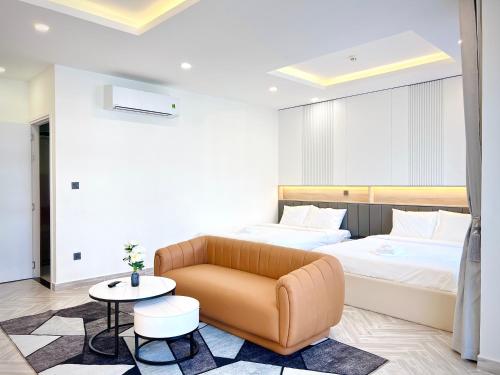 1 dormitorio con cama, sofá y mesa en Rainbow Motel, en Phu Quoc