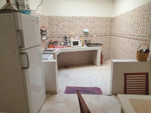 een keuken met een koelkast en een magnetron bij Logement a 8mn de mehdia in Kenitra