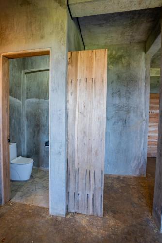 a bathroom with a wooden door and a toilet at Izustarri in Burgos