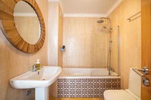 La salle de bains est pourvue d'une baignoire, d'un lavabo et d'un miroir. dans l'établissement Big Wave Front Row - Two Bedroom, à Nazaré